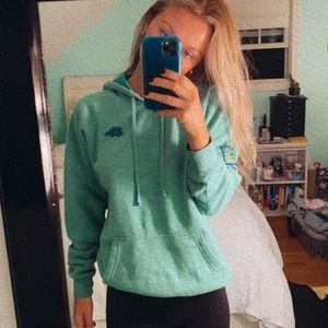 Wears woody surf green sweatshirt